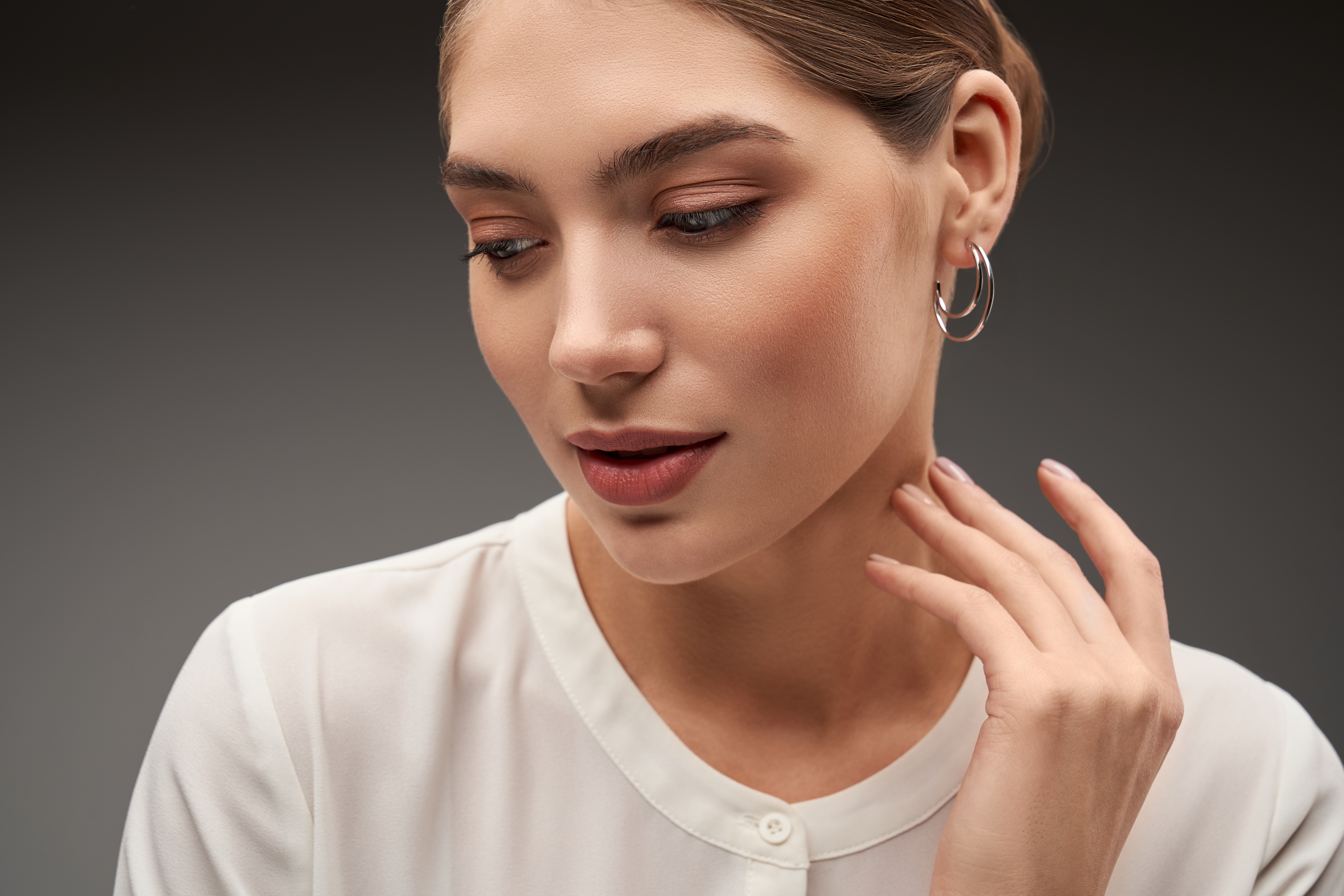 Model demonstrating silver earrings.
